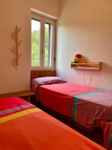 two beds in a room with a window at Pink House in Perdifumo