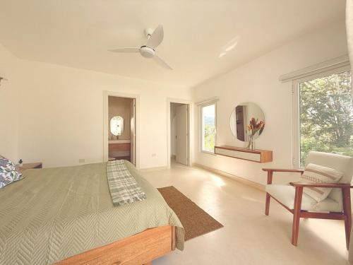 une chambre avec un lit et un ventilateur de plafond dans l'établissement Charming Villa GUGI in Playa Coson, à Las Terrenas