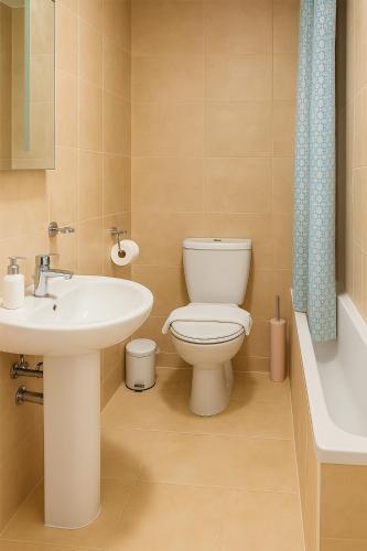 a bathroom with a toilet and a sink at Watercress Barns in Sittingbourne