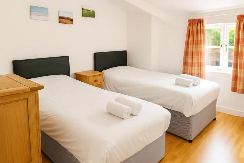ein Schlafzimmer mit zwei Betten und einem Fenster in der Unterkunft Watercress Barns in Sittingbourne