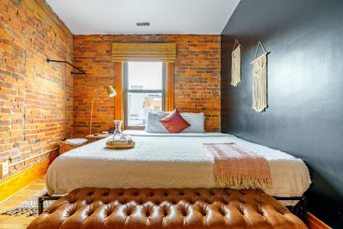 ein Schlafzimmer mit einem großen Bett und einer Ziegelwand in der Unterkunft Jungle House Columbus Downtown Free Parking Sleeps 8 - Walk to Convention Center & Nationwide Arena - 1BR Short North Luxury Home - Over 5,800 Five Star Stays in Columbus