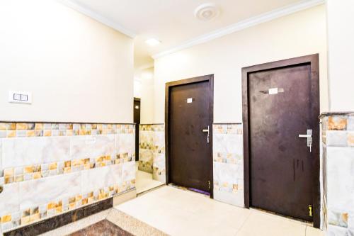 two doors in a room with tiles at Hotel O Barsana in Pātipukur