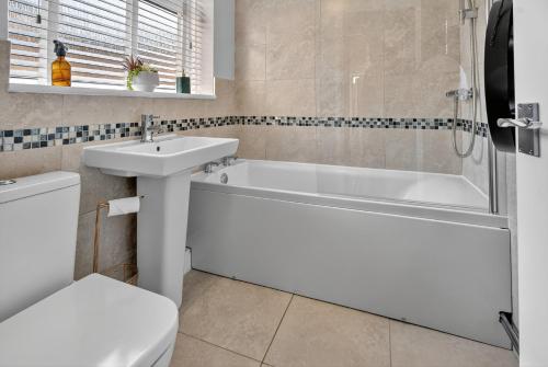 een badkamer met een wit bad en een wastafel bij Windsor Jay in York
