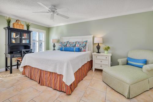 a bedroom with a bed and a chair and a desk at Beach Club #414 in Saint Simons Island