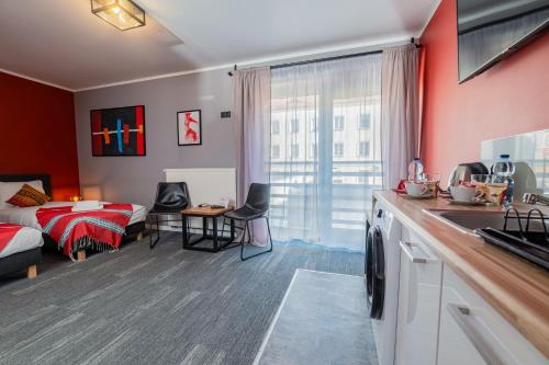 une chambre avec un lit et une cuisine avec un évier dans l'établissement Kaktus Chill & Sleeping - 50 m od Rynku, à Racibórz