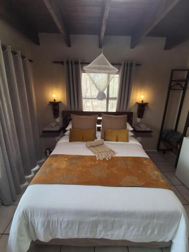a large bed in a room with a window at Figtree Escape in Marloth Park