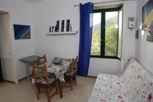 a dining room with a table and chairs and a window at Casa Rosa appartamento con giardino in Cetara