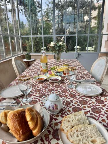una mesa con platos de pan y vasos de zumo de naranja en La Bastide des Trembles, en Marsella