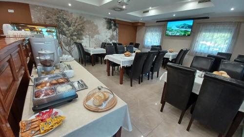 um restaurante com mesas e cadeiras com comida em Csillag Panzió em Vác