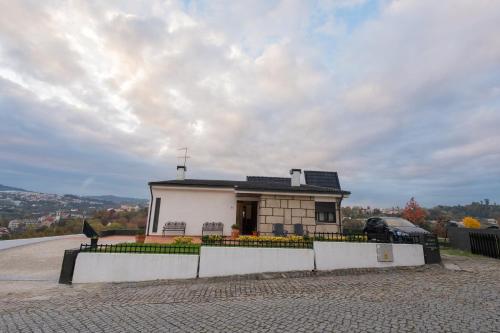 a small white house with a fence in front of it at Casa da Luisinha in Amarante