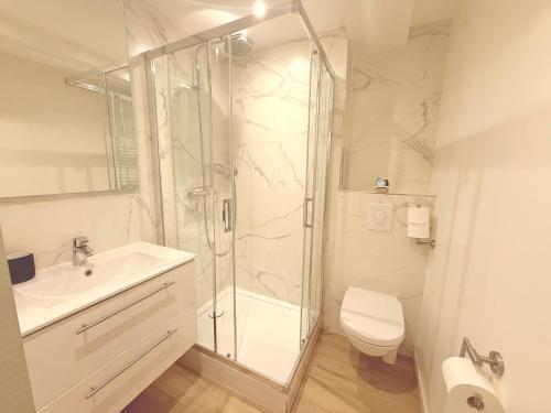 Un baño con ducha, lavabo e inodoro. en ENA 3 pièces neuf entre centre et gare, en Estrasburgo