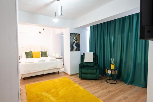a bedroom with a bed and a green chair at Apartament de închiriat Accommodation nr 10 in Suceava