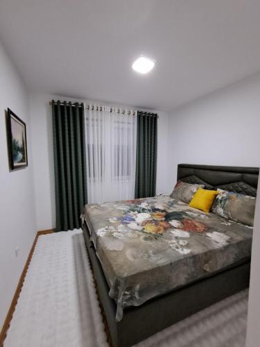 a bedroom with a large bed and a window at Apartman PETRA QUEEN in Plužine