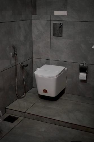 a bathroom with a toilet in a shower stall at Nirvanica Retreat Wayanad in Padinjarathara