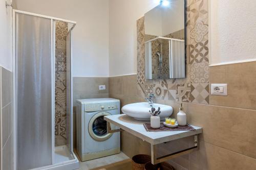une salle de bain avec un lavabo et une machine à laver dans l'établissement Domo Clelia, à Nulvi