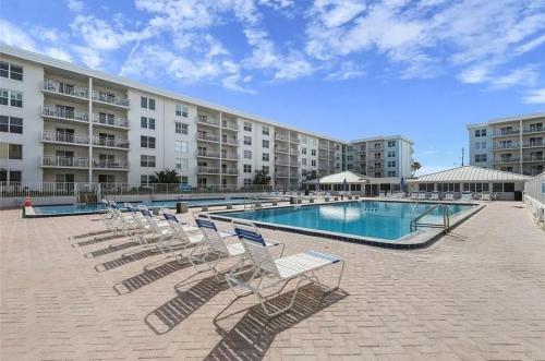 a swimming pool with lounge chairs in front of a building at Oceanfront Retreat Private Beach New Smyrna Beach in New Smyrna Beach