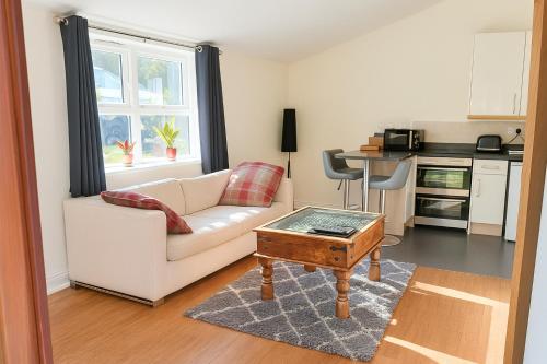 ein Wohnzimmer mit einem weißen Sofa und einem Couchtisch in der Unterkunft Watercress Barns in Sittingbourne