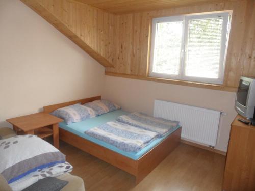 niewielka sypialnia z łóżkiem i telewizorem w obiekcie Bea w mieście Międzywodzie