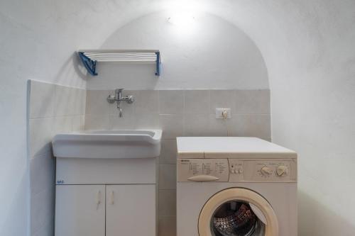 eine Waschküche mit Waschmaschine und Waschbecken in der Unterkunft Casa Carmela 53 in Ragusa
