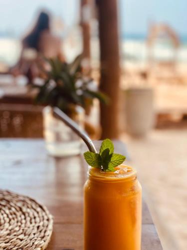 a drink with a mint leaf on top of a table at Sunset Haven in Habaraduwa Central