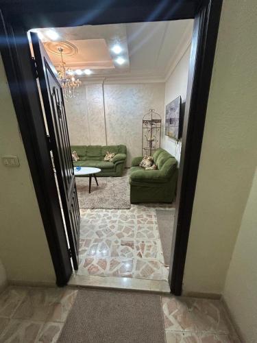 a door leading into a living room with a couch at Toum's Apartments 2 in Amman