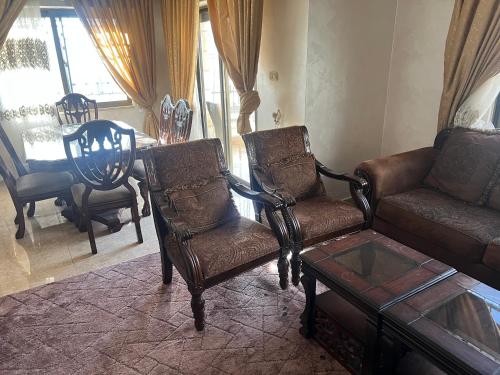 salon z kanapą, krzesłami i stołem w obiekcie كرم الضيافة w mieście Amman