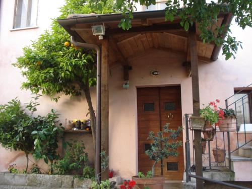 una casa con una puerta de madera y un árbol en Agriturismo La Fattoria, en San Donato Val di Comino