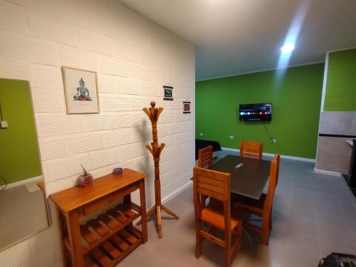 a dining room with green walls and a table and chairs at Dptos Ceci in Centenario