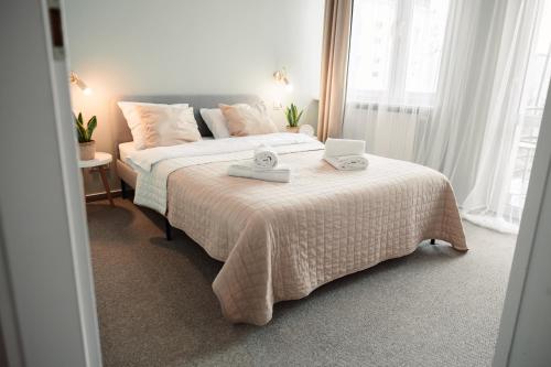 a bedroom with a bed with a laptop on it at Apartament Szczerbowskiego A in Lublin