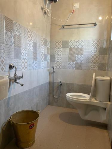 ein Badezimmer mit einem WC, einer Dusche und einem Eimer in der Unterkunft Vishnu VAASAM Serviced Apartment Srirangam in Tiruchchirāppalli