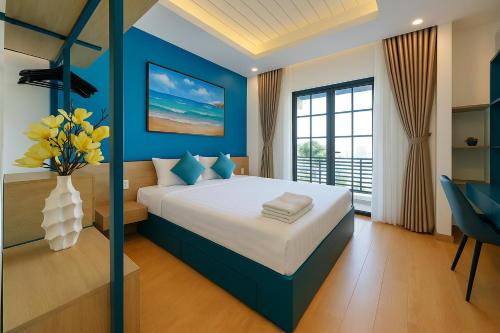 une chambre bleue avec un lit avec un vase de fleurs dans l'établissement The Moon Villa - NOVAWORLD Phan Thiet, à Bình Tú
