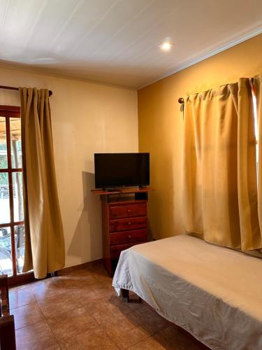 une chambre avec un lit et une télévision à écran plat dans l'établissement Altos de Artalaz, à Colón