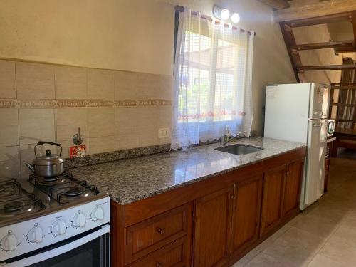 Il comprend une cuisine équipée d'une cuisinière et d'un réfrigérateur blanc. dans l'établissement Altos de Artalaz, à Colón