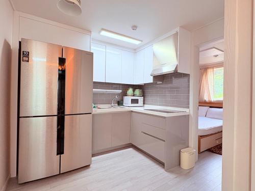 La cuisine est équipée d'un réfrigérateur et d'un évier. dans l'établissement MAYs GO DUCK Newly built Family Stay KSPO IKEA Lotte World, à Séoul