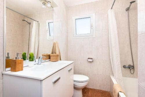 a white bathroom with a toilet and a shower at Villa Iris Prima by Villa Plus in Punta Prima
