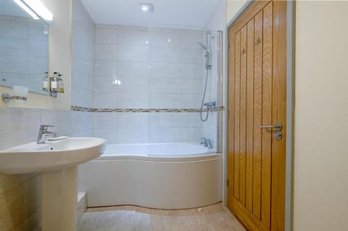 a bathroom with a tub and a sink and a bath tub at Teign Cottage in Broadhempston