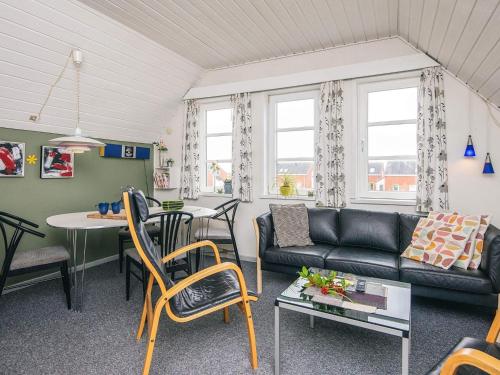a living room with a couch and a table at 4 person holiday home in Rømø in Sønderby