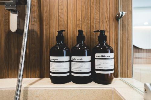 a group of four bottles sitting on a shelf in a bathroom at DadamHotel in Suwon
