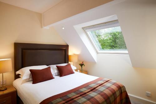 a bedroom with a large bed with a window at Elmers Court in Lymington