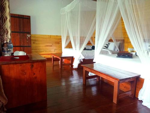 une chambre avec deux lits avec rideaux et parquet dans l'établissement NETHSARA cottage, à Ella