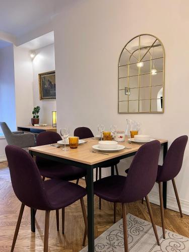 a dining room with a wooden table and purple chairs at Reval Residences Old Town in Tallinn