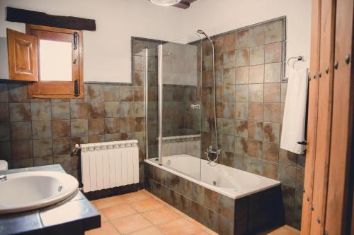 a bathroom with a tub and a sink at Casa Rural La Vega Piscina, naturaleza y vistas in San Vicente de Alcántara