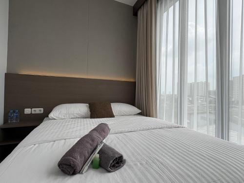 a hotel room with a bed with towels on it at TJ Brother Residences Cengkareng in Jakarta
