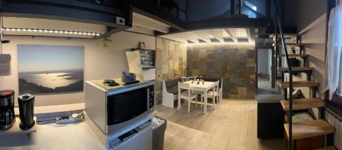 a room with a tv and a dining room with a table at Casaldo in Gardone Riviera