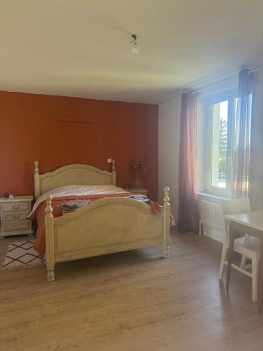 ein Schlafzimmer mit einem Bett und einem Tisch und einem Fenster in der Unterkunft La chambre clé de la forêt in Métairies-Saint-Quirin