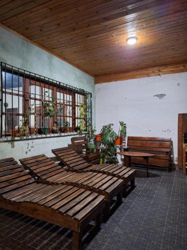 a room with wooden tables and benches and windows at EL ESTABLO - Casa de Campo Vacacional con pileta privada - Jujuy in San Salvador de Jujuy