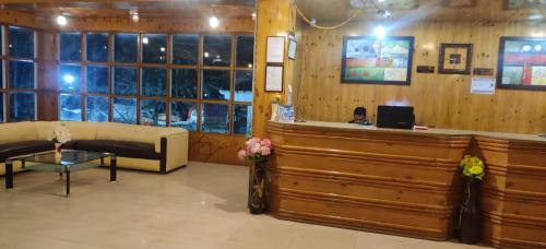 a lobby with a woman sitting at a cash register at ishaan resorts near mall road 10 min walk and big parking in Jāmb