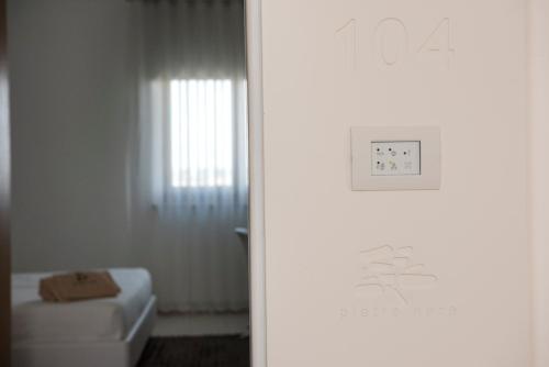 a white bathroom with a toilet and a window at Pietre Nere Resort & Spa in Modica