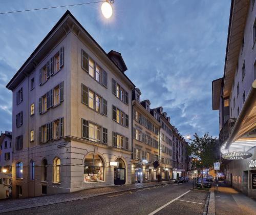 Un gran edificio en una calle de la ciudad por la noche. en Sorell Hotel Rütli Niederdorf Zürich, en Zúrich
