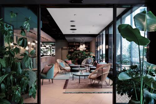 苏黎世Sorell Boutique-Hotel St Peter Zürich的一间种有植物和桌椅的餐厅